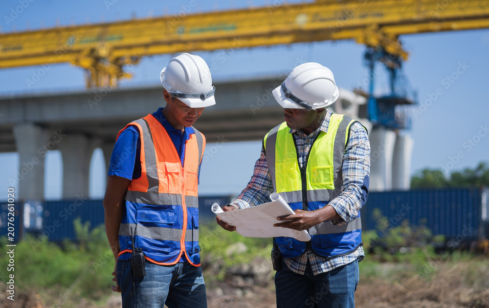 Équipe d'ingénieurs examinant des plans sur un chantier d'infrastructure